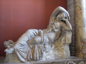 A pale sculpture of a reclined woman, Ariadne, who is seemingly halfway between sleeping and awaking.