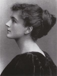 Black and white photo Edith Wingate Rinder. The photograph is taken at a side profile, she wears a dark gown and her hair is tied in a bun.